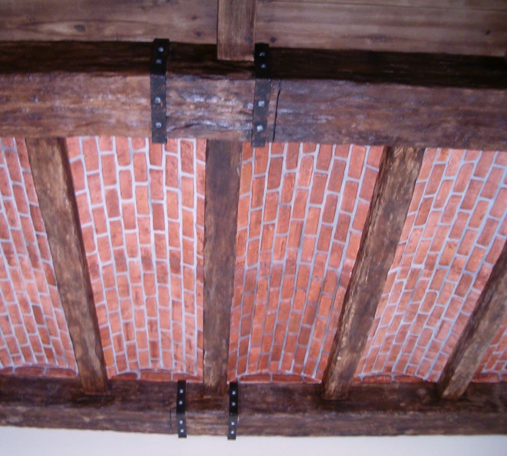 Techo de escayola que recrea una decoración rústica.