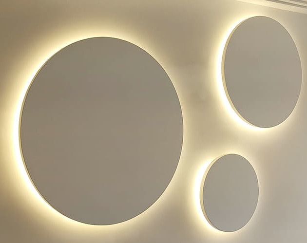 Círculos situados en la pared con luz indirecta.